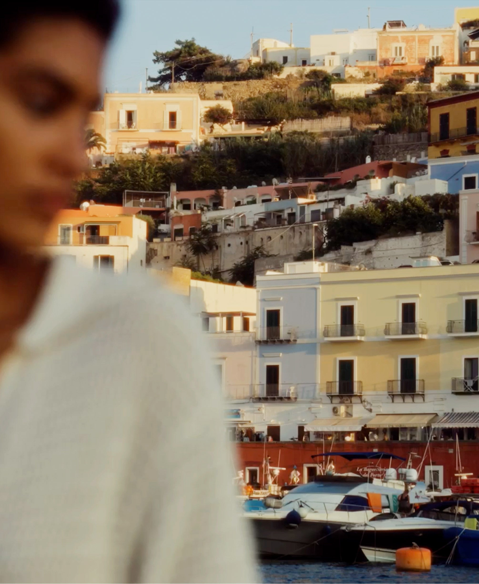 Woman in front of Ponza buildings.