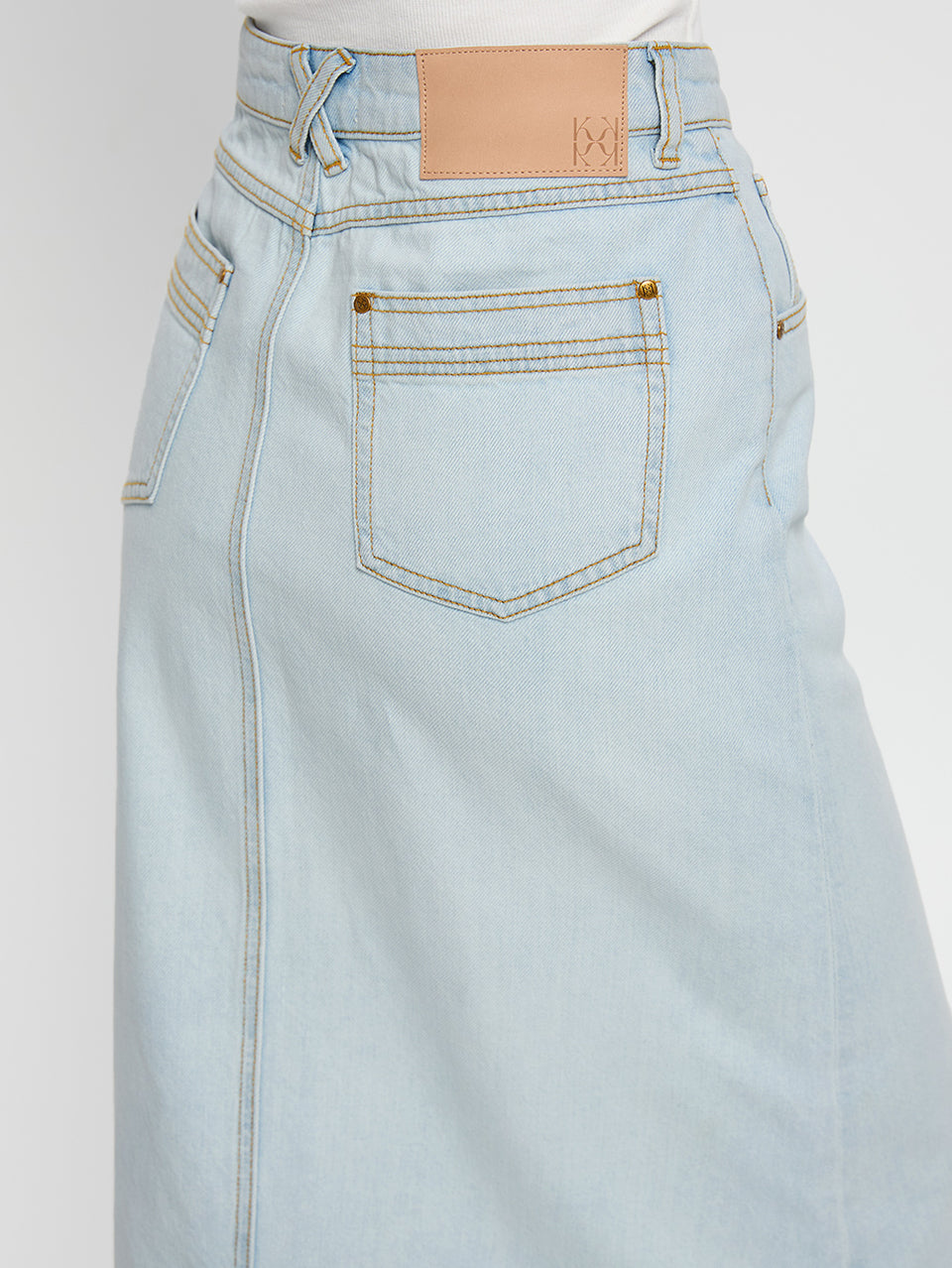 Zoya Skirt KIVARI | Model wears pale blue denim skirt detail shot